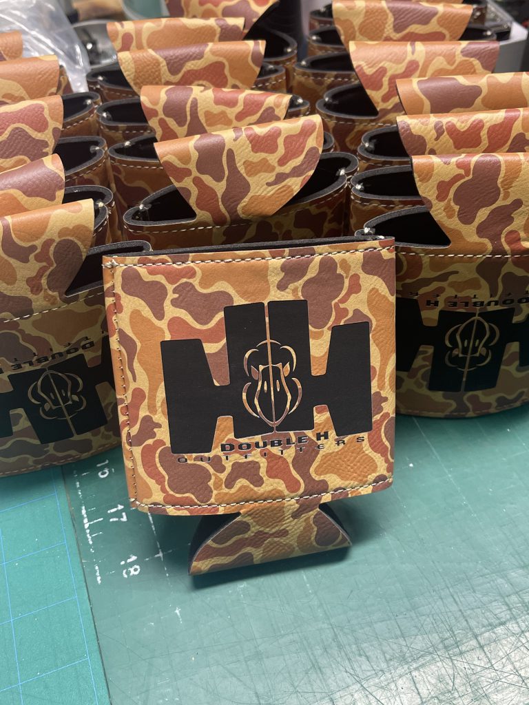 Camo leatherette can coolers engraved in black with the Double H Outfitters HH mark