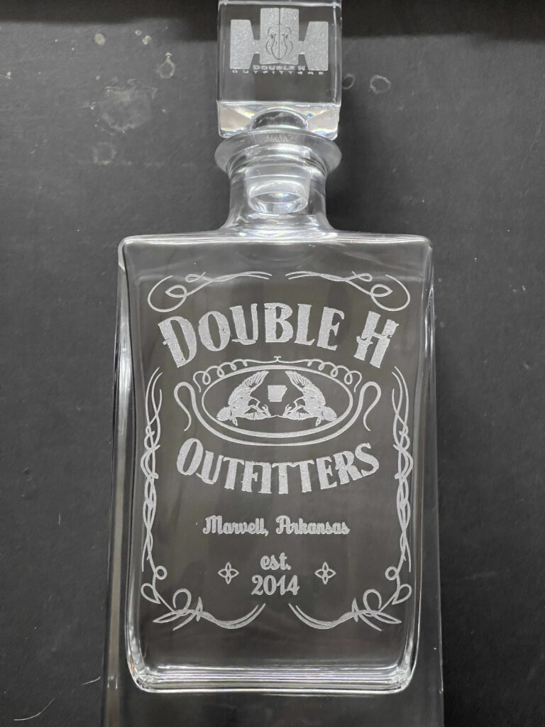 Glass decanter engraved with a Double H Outfitters label design reading Marvell, Arkansas, est. 2014