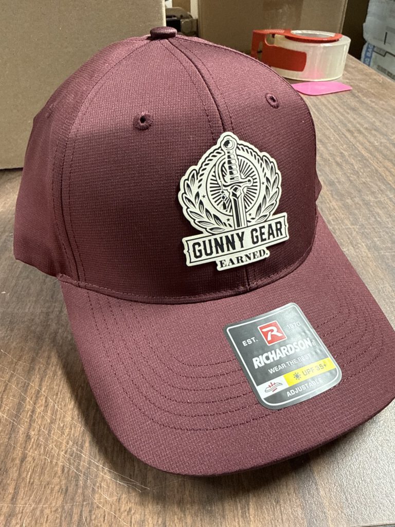 Maroon hat with a white and black Gunny Gear patch