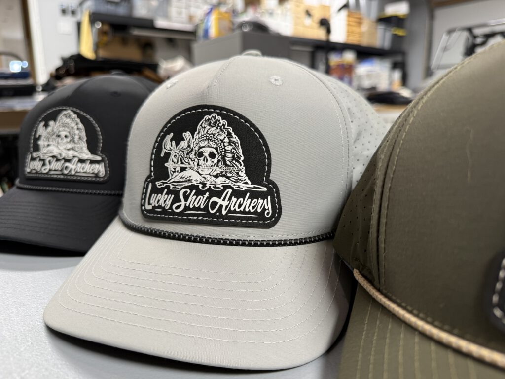 Light gray rope hat with a black and white Lucky Shot Archery skull-and-headdress patch