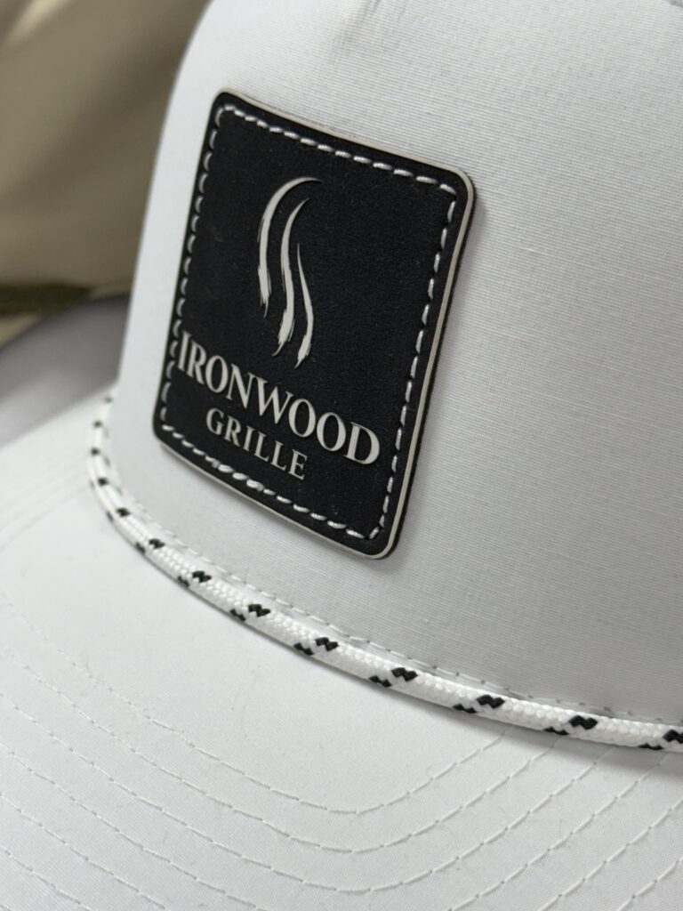 White rope hat with a black leatherette Ironwood Grille patch, the logo in white