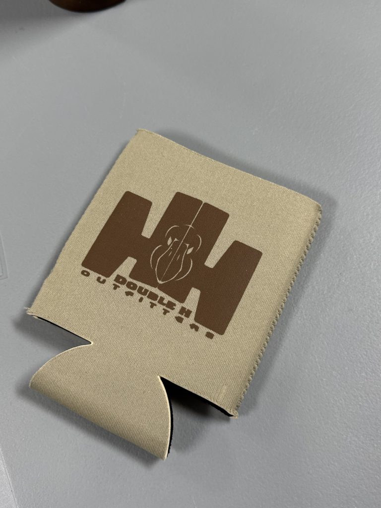 Tan leatherette can cooler engraved in brown with the Double H Outfitters HH mark