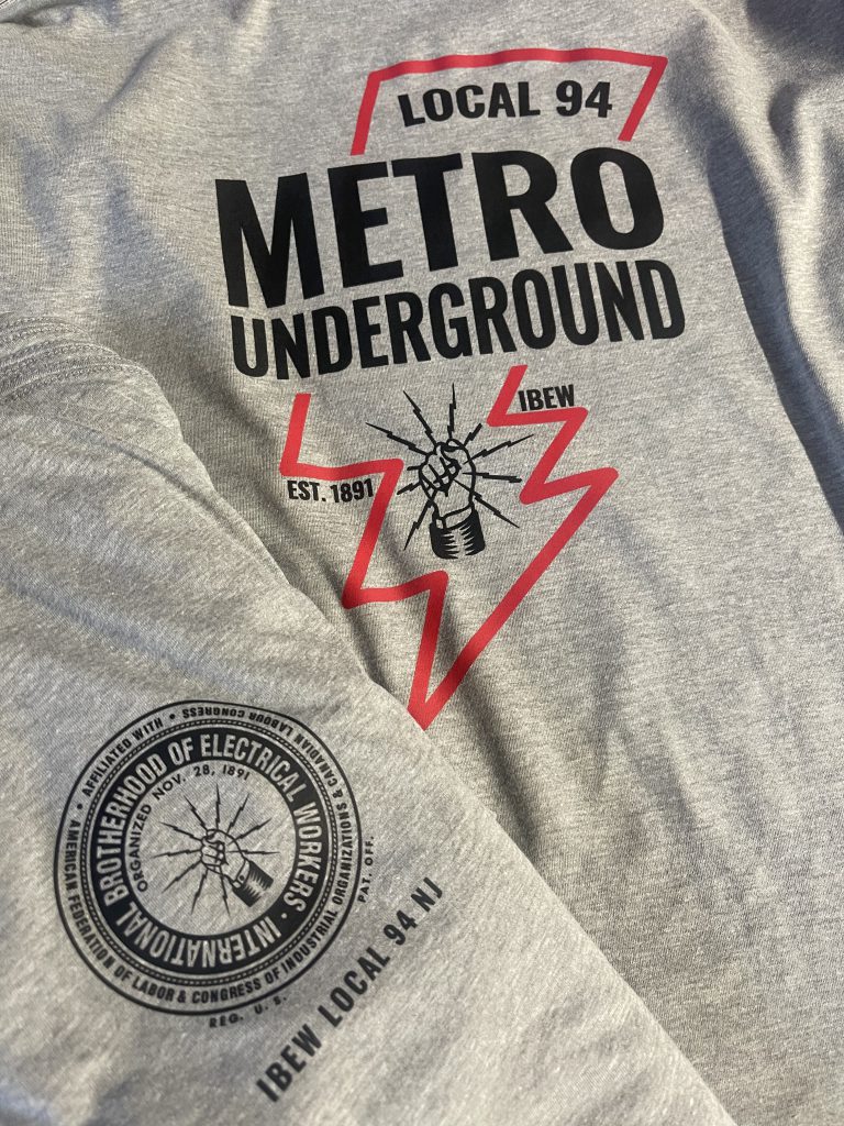 Gray tee printed with the IBEW Local 94 Metro Underground design in black and red, with the union seal on the sleeve