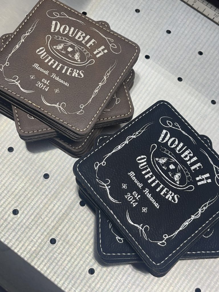 Square leatherette coasters in brown and black, engraved with the Double H Outfitters label design reading Marvell, Arkansas, est. 2014