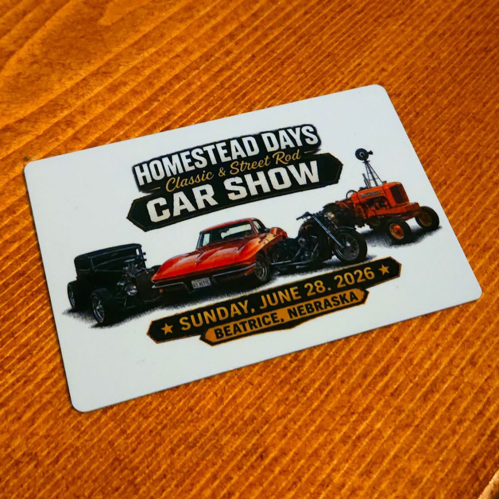 Full-color dash plaque for the Homestead Days Classic & Street Rod Car Show, Sunday, June 28, 2026, in Beatrice, Nebraska, with a hot rod, a red sports car, a motorcycle and an orange tractor by a windmill